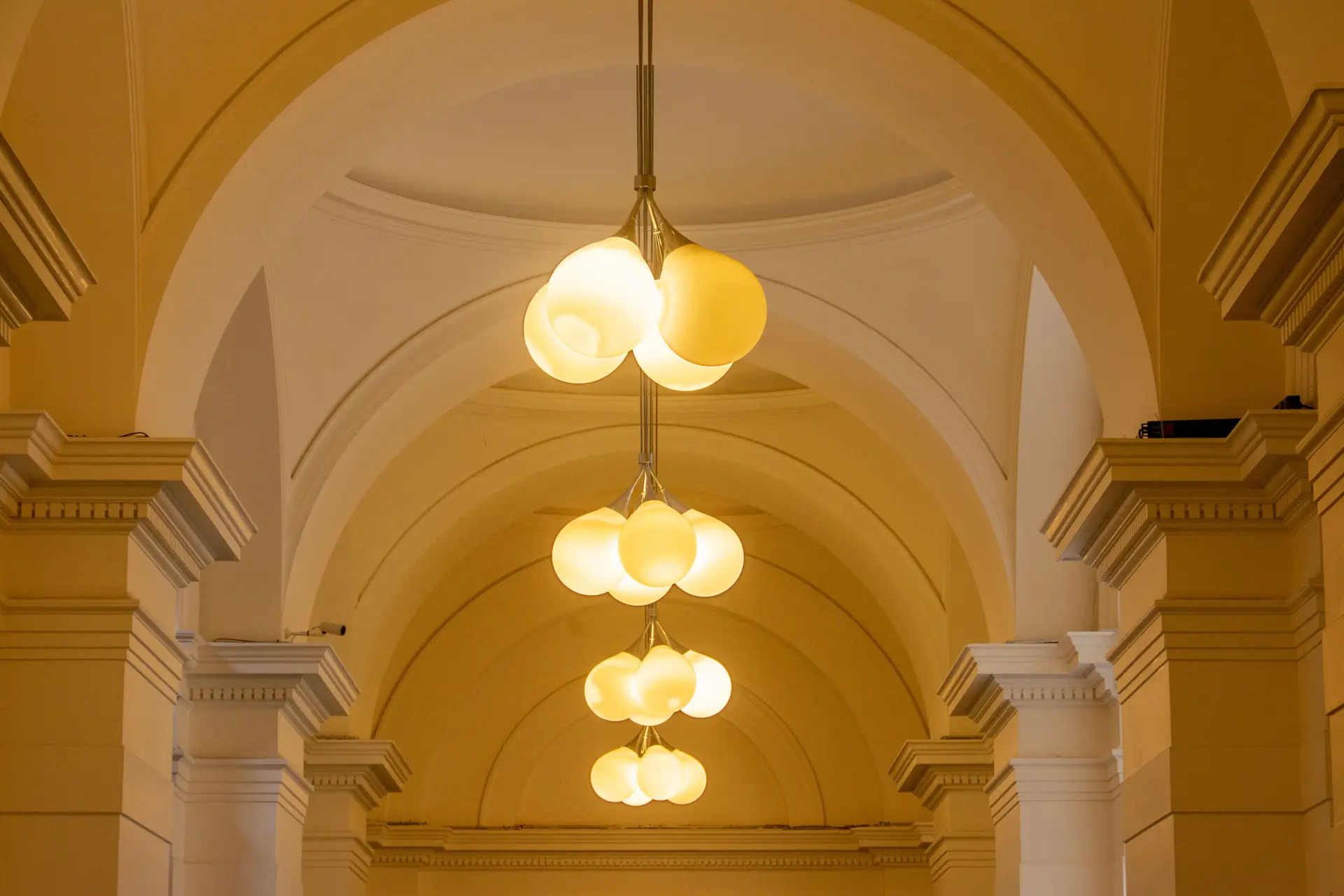 Grand architectural interior with subtle rhythmic illumination highlighting natural material seams