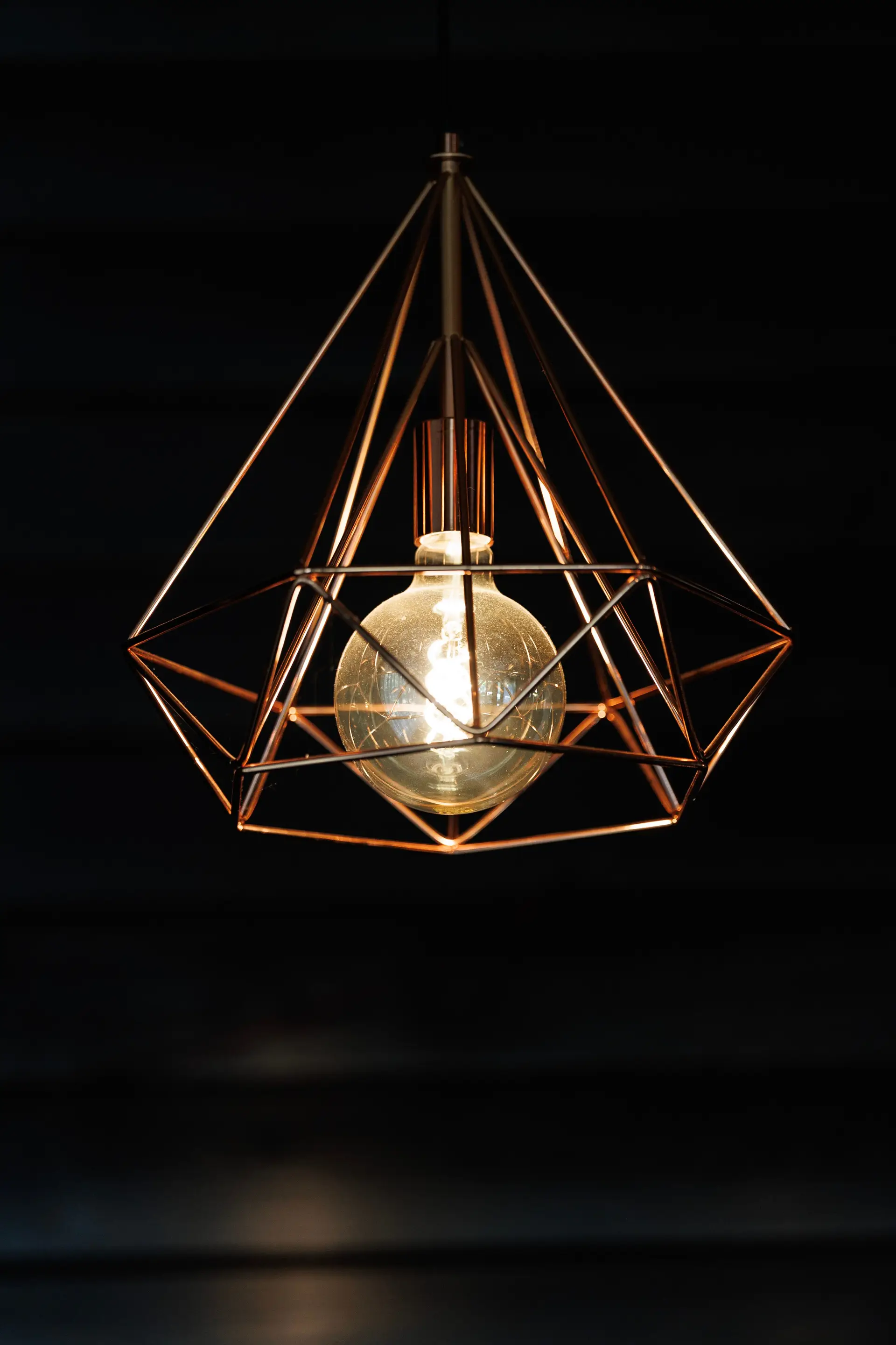 Architectural wall sconce casting symmetric geometric light beams