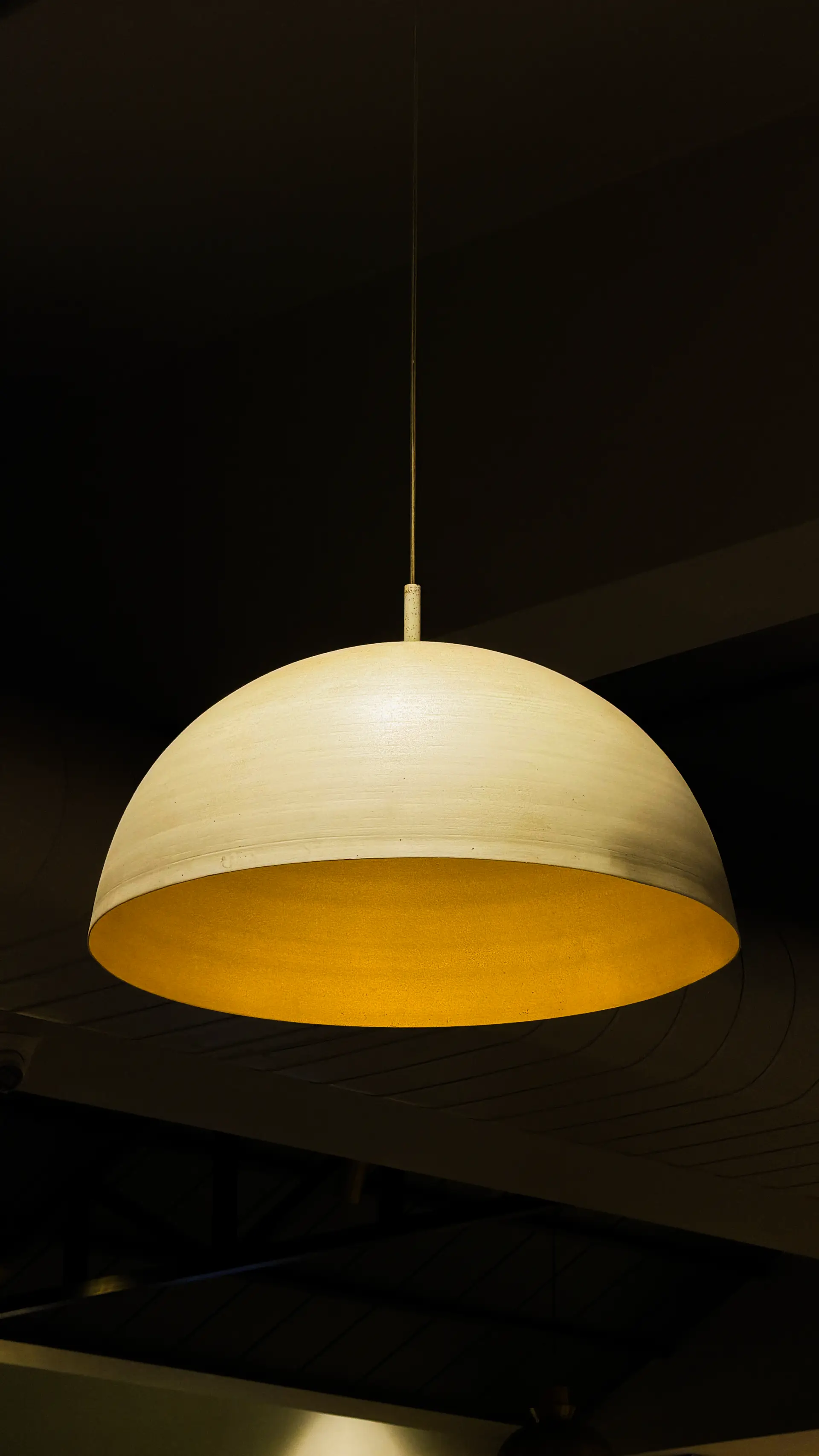 Sculptural pendant luminaire glowing with warm illumination