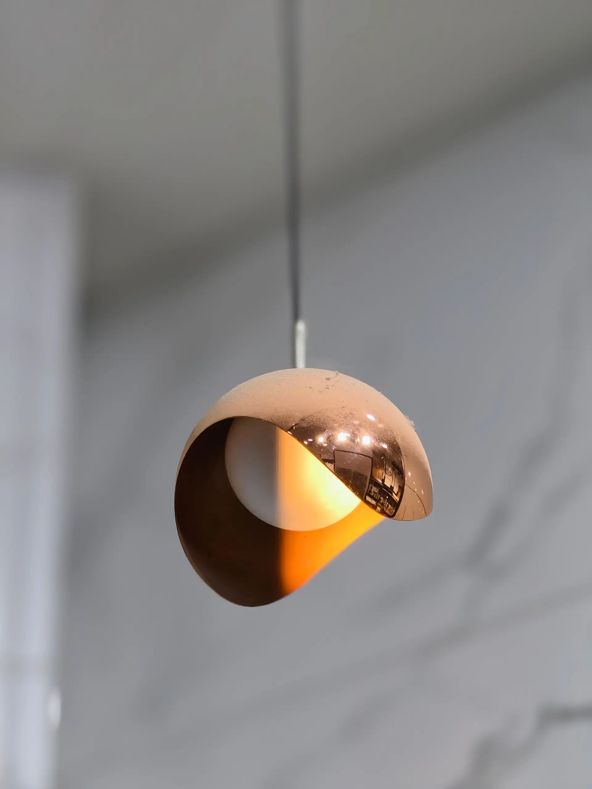 Brushed copper pendant light fixture detail showing refined material joint